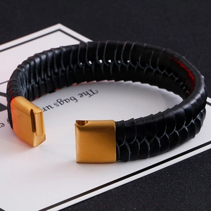 Braided black leather bracelet with gold stainless steel clasp in a modern industrial style