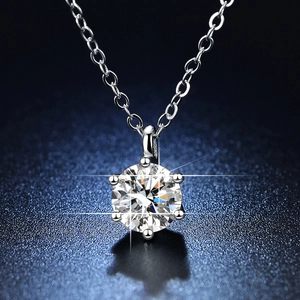 Macro shot of 1 carat moissanite pendant with classic six-prong setting on starry blue background