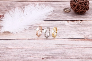 Detailed close-up of heart-shaped shell rings in rose gold, silver, and gold finishes