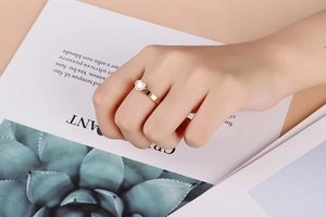 Detailed close-up of rose gold stainless steel ring featuring a white heart shell inlay
