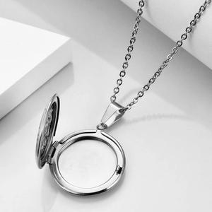 Detailed view of an open silver round locket pendant with an O-shaped rolo chain