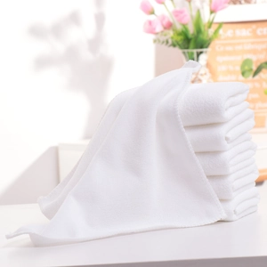 Close-up of white hotel towel texture with soft terry loops and folded stack detail