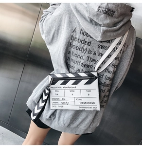 Detail of clapperboard crossbody bag with Wonderland print and wide striped strap