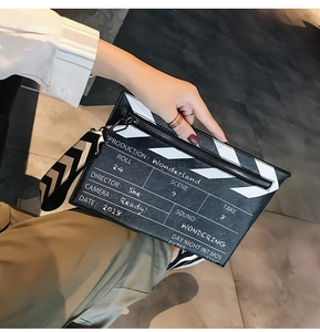 Detail view of film clapperboard crossbody bag with decorative production text and wide strap