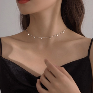 Detail shot of a silver choker with delicate round discs and beads on a thin chain