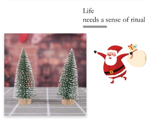 Close-up of mini snow-tipped Christmas trees with pine needles and wooden base