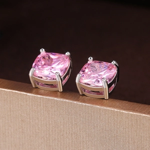 Macro shot of princess cut pink zircon stud earrings in silver four-prong setting