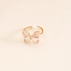 Close-up of golden butterfly ring with faceted pink glass crystals and open band design
