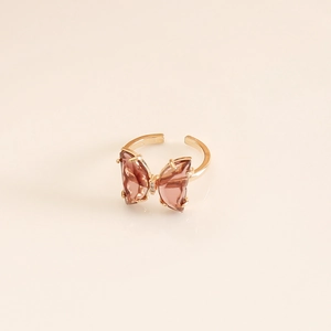 Macro view of gold ring with translucent amber glass butterfly wings and open band