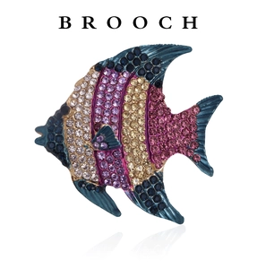 Close-up of a fish-shaped brooch featuring colorful rhinestones on a metal base