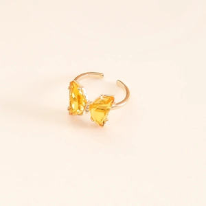 Detail of yellow crystal butterfly ring featuring a gold-plated adjustable open band