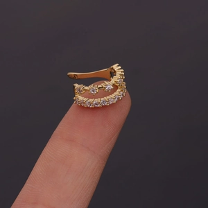 Detailed close-up of a U-shaped gold ear cuff with shimmering zircon stone inlay