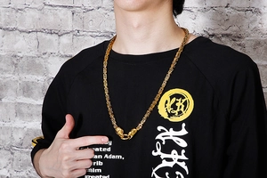 Close-up of golden heavy chain necklace with lion head details worn on a street style model