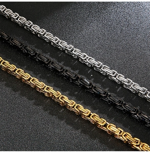 Close-up of Byzantine weave necklaces in silver, black, and gold stainless steel finish
