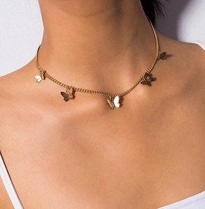 Primo piano della collana dorata con pendenti a farfalla indossata da una donna