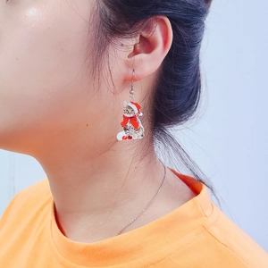 Cute Christmas cat earrings with red hat and bow worn by a model for holiday style