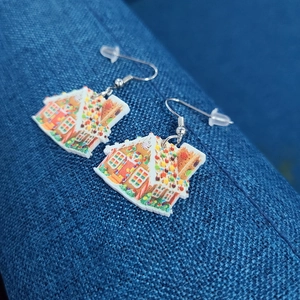 Macro shot of colorful acrylic gingerbread house earrings with secure silicone backs