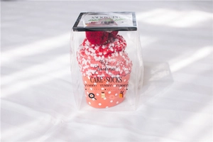 Detail of coral fleece cake socks in gift box with red plush ball decoration