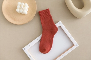 Detail of rust red thick cotton crew socks with ribbed cuffs for winter warmth