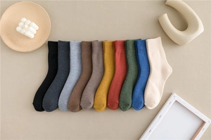Detailed flat lay of ten colorful mid-calf thick cotton socks arranged in a fan shape