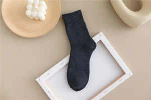 Detailed view of thick dark grey ribbed cotton socks arranged with minimalist home decor