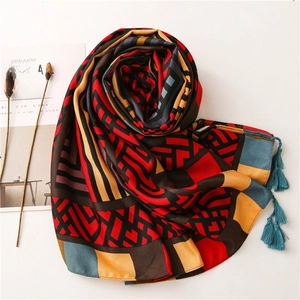 Detailed view of lightweight linen scarf with geometric patterns and blue fringe trim