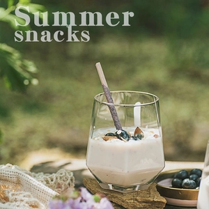 Detail shot of a minimalist glass cup with yogurt and blueberries on a stone surface