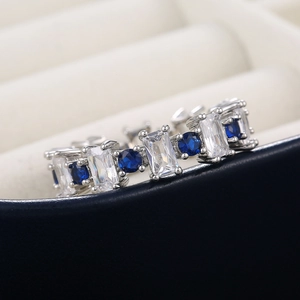 Gros plan d'une bague en argent avec zircons baguettes et pierres bleu foncé