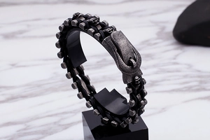 Detail of punk leather bracelet with skull motifs and buckle on marble background