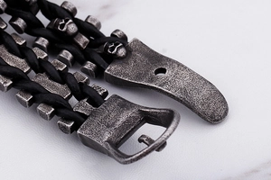 Gros plan d'un bracelet en cuir tressé gothique pour homme avec crâne et boucle