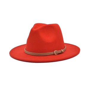 Detail of red wool felt fedora hat featuring a camel leather strap with golden buckle