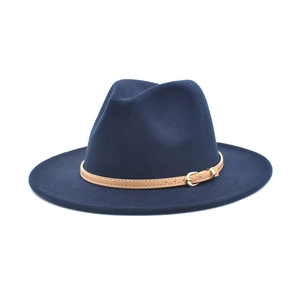 Detail of navy blue wool fedora hat featuring a brown leather band and gold metal buckle