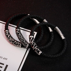 Set mit drei schwarzen geflochtenen Lederarmbändern und silbernen Metallanhängern im Punk-Stil