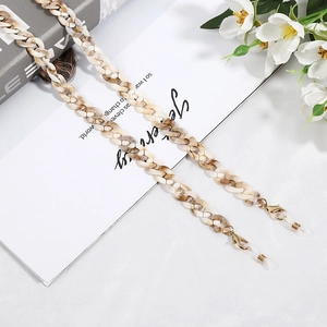 Detail of amber acrylic glasses chain with lobster clasp on a stylish white setting