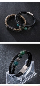 Detail of green beaded lion head charms and magnetic clasp on woven leather bracelets