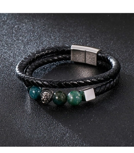 Macro shot of double-layer black braided leather bracelet with silver lion and green stone