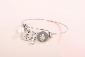 Detail of silver stainless steel charm bracelet with shell pearl and family pendants