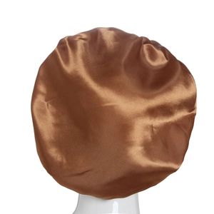 Detail of a brown satin sleep cap showing smooth, glossy fabric on a white mannequin head