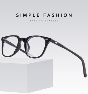 Detail of minimalist black full-rim eyewear frame with rectangle metal hinge accents