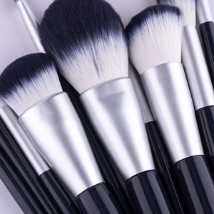 Dettaglio macro di setole sintetiche sfumate bianco e nero su pennelli trucco professionali