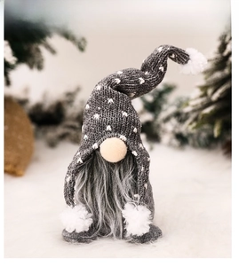 Close-up of Christmas gnome with grey knitted heart hat and long faux fur beard decoration