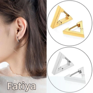 Macro shot of gold and silver geometric triangle huggie earrings in minimalist style
