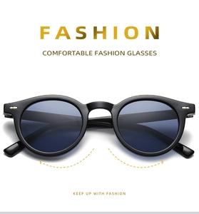Close-up of classic round black sunglasses with translucent gray lenses and metal hinge details