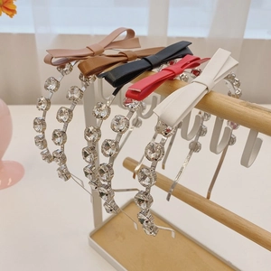 Detailed view of rhinestone headbands with crystal bow accents in five various colors
