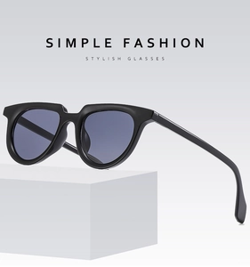 Detail shot of black rectangular small frame sunglasses on a white geometric display