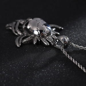 Detailed close-up of a silver punk skull pendant with intricate wing patterns on rope chain