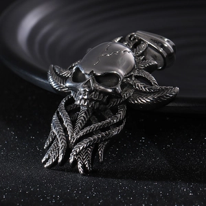 Macro shot of silver stainless steel skull pendant with textured wing details and metal finish