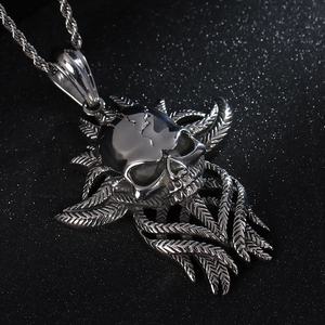 Detailed close-up of a silver punk skull pendant with metallic wing feathers and twist chain