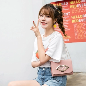 Pink crossbody chain bag with golden lip-shaped buckle and star detail on model