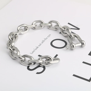 Macro shot of silver horseshoe buckle detail on hip-hop style chunky chain bracelet